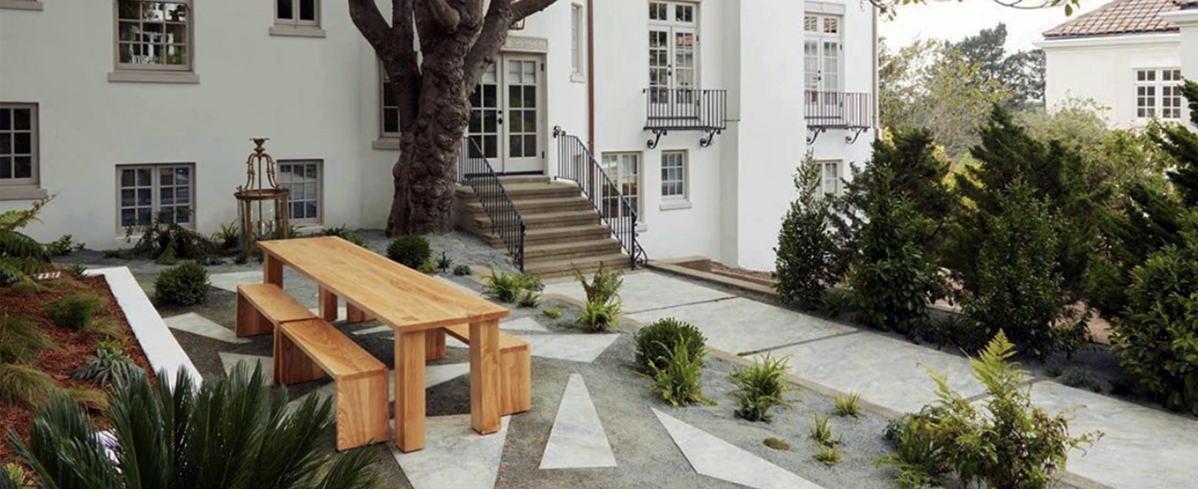Professional patio landscaping design and implementation of modern grill, table and foreplace for classic San Francisco building.