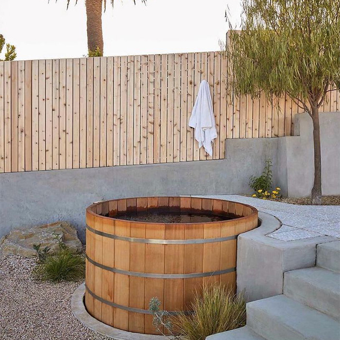 Landscape design & construction on a slope of a San Francisco hill including concrete, wood and stones to create a desert theme with large benches, walking paths and a wooden hot tub.