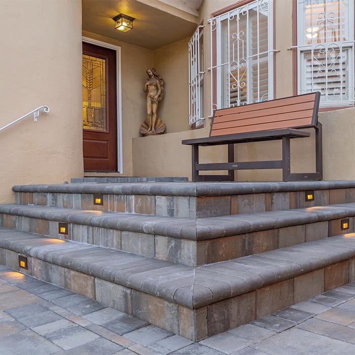 A classic hardscaping project based on large stone steps with embedded lights, adding a traditional classic touch.